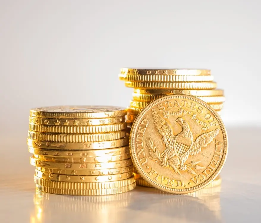 Gold coins stacked on a light surface